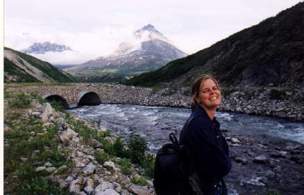 Alison in front of a stream and a mountain in the Yukon